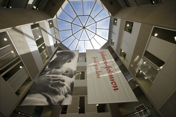 FILE - In this July 30, 2013, file photo, large banners hang in an atrium at the headquarters of Johnson &amp; Johnson in New Brunswick, N.J. Johnson &amp; Johnson reports financial results on Tuesday ...