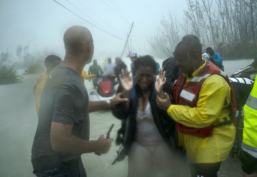 Volunteers rescue several families that arrived on small boats, from the rising waters of Hurricane Dorian, near the Causarina bridge in Freeport, Grand Bahama, Bahamas, Tuesday, Sept. 3, 2019. The st ...