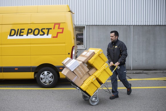 Paketzusteller der Schweizerischen Post Halid Dursun befoerdert Pakete auf einer Sackkarre fuer die Zustellung zum Kunden, aufgenommen am Montag, 15. November 2021 in Zuerich. (KEYSTONE / Ennio Leanza ...