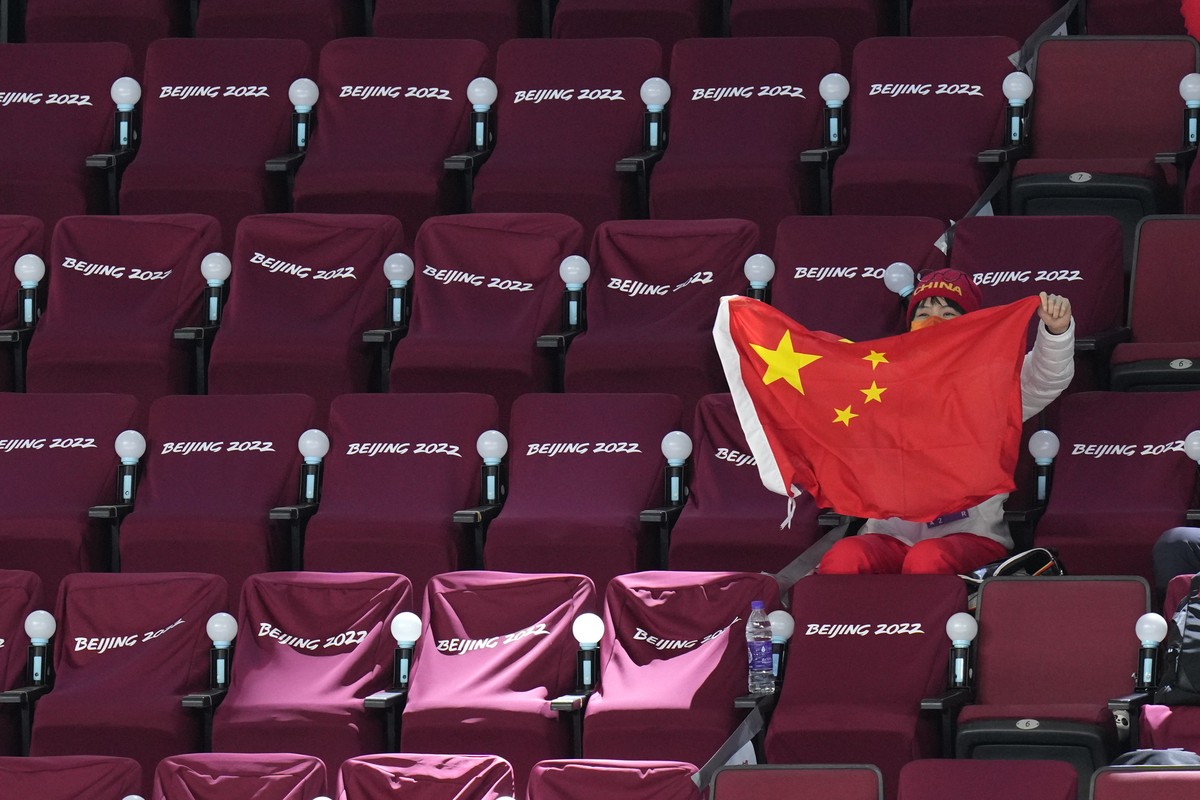 A spectator waves a Chinese flag during a preliminary round women's hockey game between China and Czech Republic at the 2022 Winter Olympics, Thursday, Feb. 3, 2022, in Beijing. (AP Photo/Petr Da ...