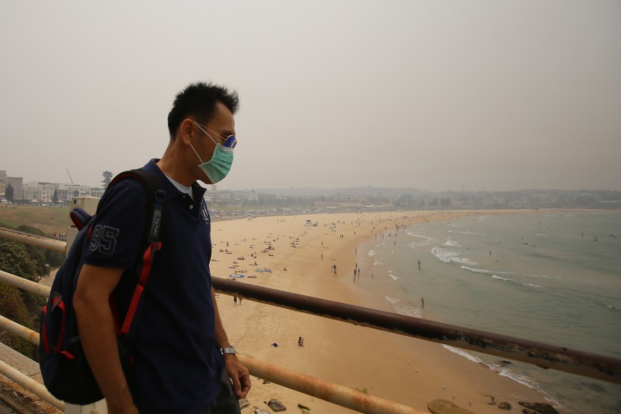 epa08058562 A man wears a mask as smoke and haze from bushfires in New South Wales hangs over Bondi Beach in Sydney, Australia, 10 December 2019. EPA/STEVEN SAPHORE AUSTRALIA AND NEW ZEALAND OUT