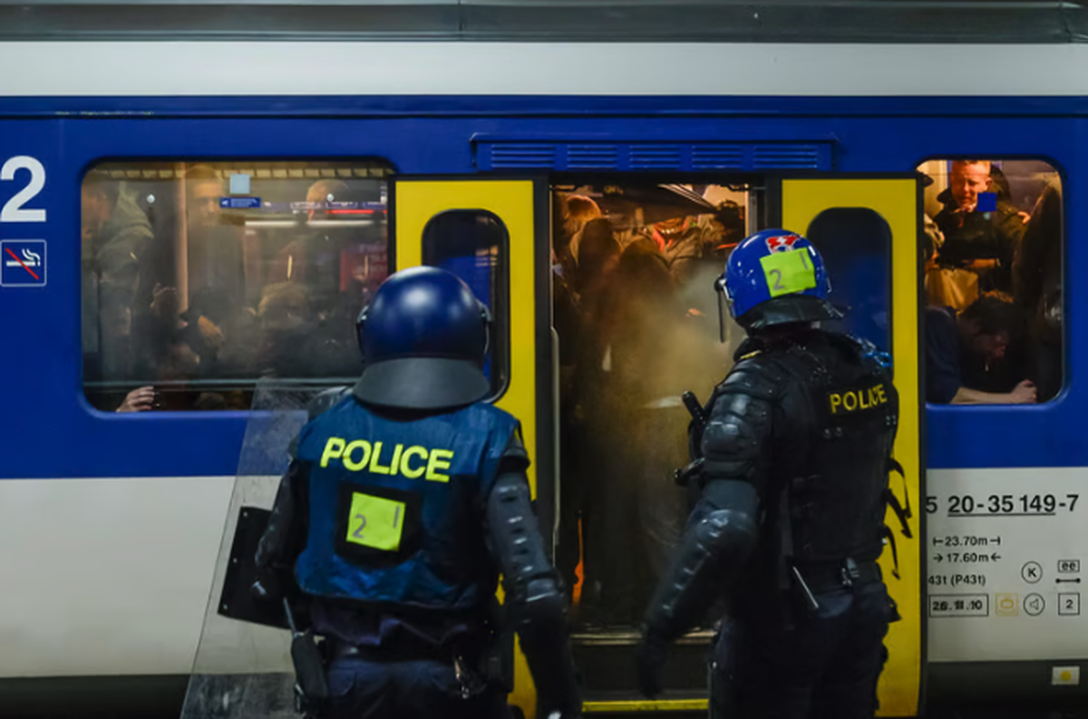 Des policiers montent à bord d'un train spécial de supporters.