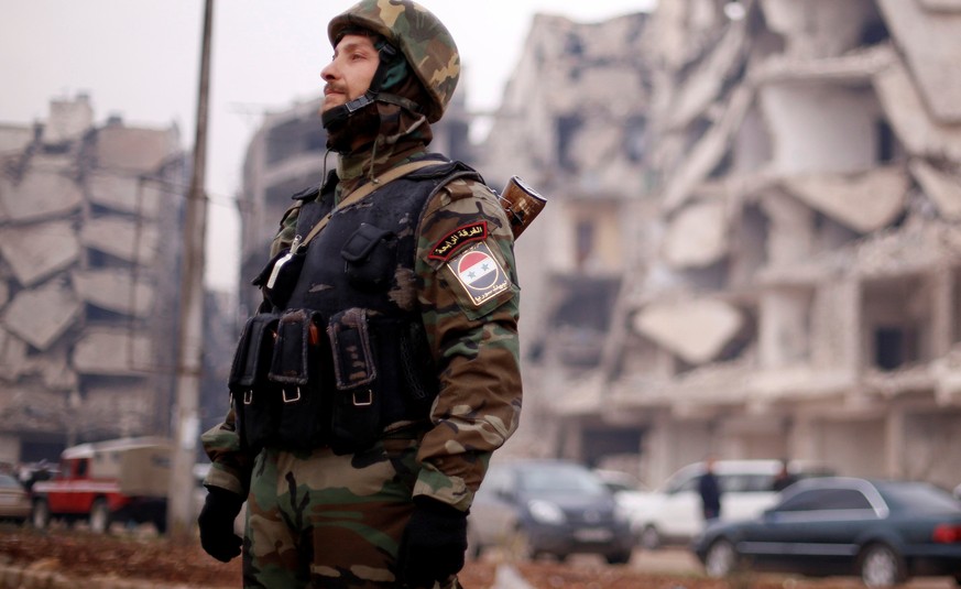 A member of forces loyal to Syria&#039;s President Bashar al-Assad stands near damaged buildings in Aleppo&#039;s Salaheddine district, Syria December 16, 2016. REUTERS/Omar Sanadiki