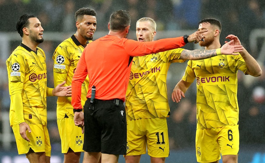 epa10939292 Marco Reus of Dortmund and teammates talk to referee Artur Dias during the UEFA Champions League Group F match between Newcastle United and Borussia Dortmund in Newcastle, Britain, 25 Octo ...