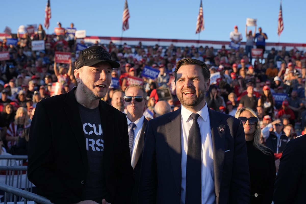 Tesla and SpaceX CEO Elon Musk, left, and Republican vice presidential nominee Sen. JD Vance, R-Ohio, listen as Republican presidential nominee former President Donald Trump speaks at a campaign event ...
