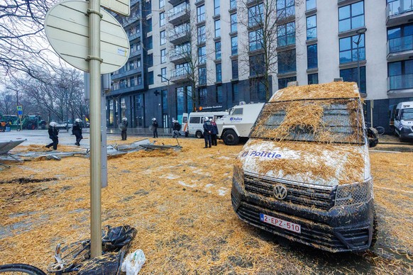 epaselect epa11182627 Police cars are covered in hay during a protest by European farmers around the Justus Lipsius Council Building at the side of a meeting of EU Agriculture and Fisheries Ministers...