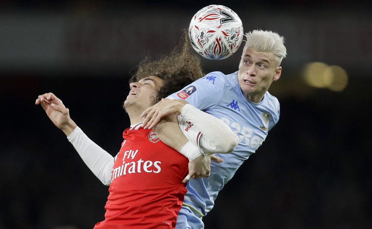 Arsenal's Matteo Guendouzi, left, and Leeds United's Ezgjan Alioski challenge for the ball during the English FA Cup soccer match between Arsenal and Leeds United at the Emirates Stadium in  ...