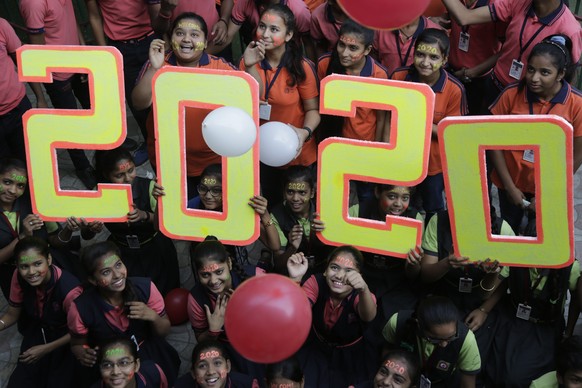 Indian school children pose for the cameras during an event to welcome the New Year in Ahmadabad, India, Tuesday, Dec. 31, 2019. (AP Photo/Ajit Solanki)