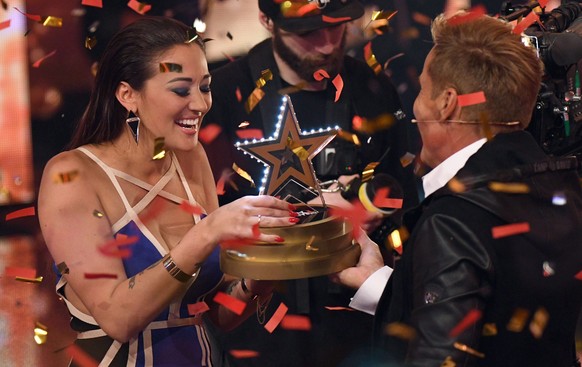 epa05680318 Member of the jury, German musician Dieter Bohlen (R) presents British singer Angel Flukes with the trophy as she celebrates her victory in the final of the tenth season of the RTL casting ...