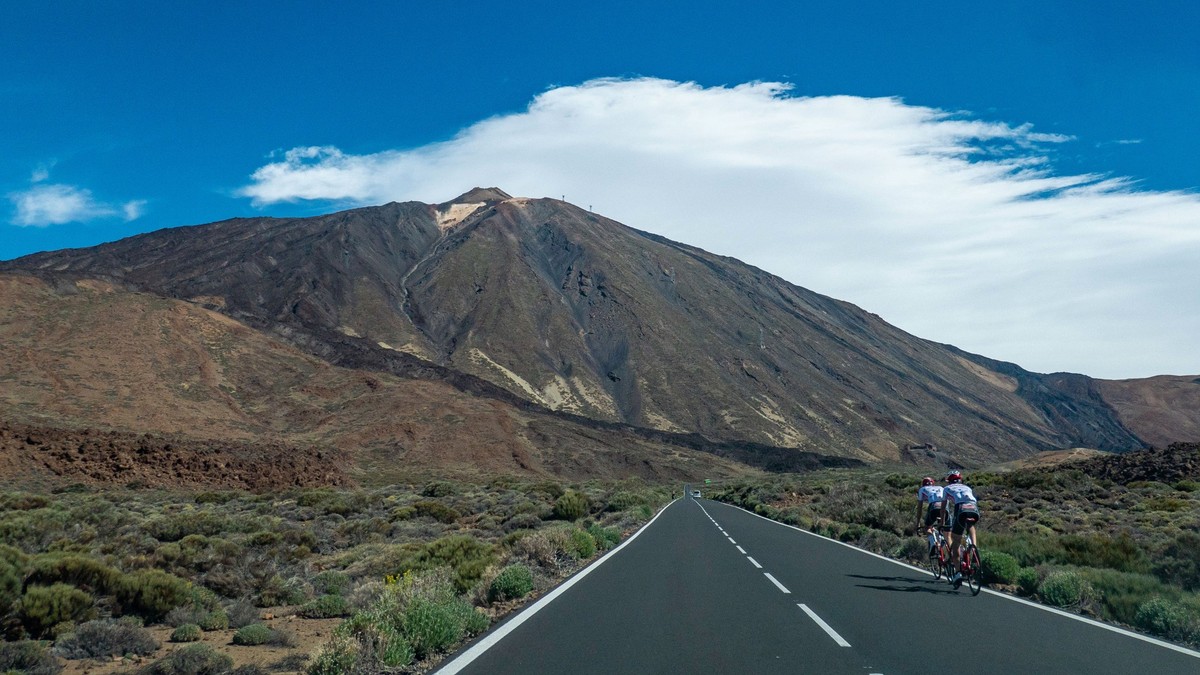 Cyclist on a road with a bicycle, bike cycling during a blue sky summer day on the famous for biking route around the volcanic landscape of El Teide Volcano and National Park in Tenerife island, Canar ...