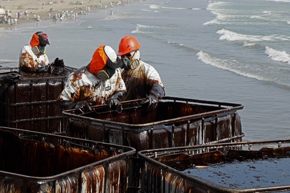 epa09709353 Workers carry out a cleaning operation on the beaches of Ventanilla, Peru, 25 January 2022. The Repsol company stated that it is &#039;closely collaborating&#039; with civil society and th ...