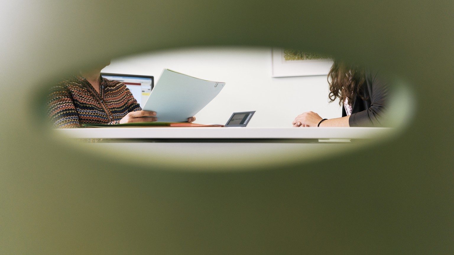 ARCHIVBILD ZU DEN ZAHLEN ZUR SOZIALHILFE 2016 --- A consultation meeting photographed through the back of a chair in an office of the social center Albisriederhaus on Albisriederstrasse in Zurich, Swi ...