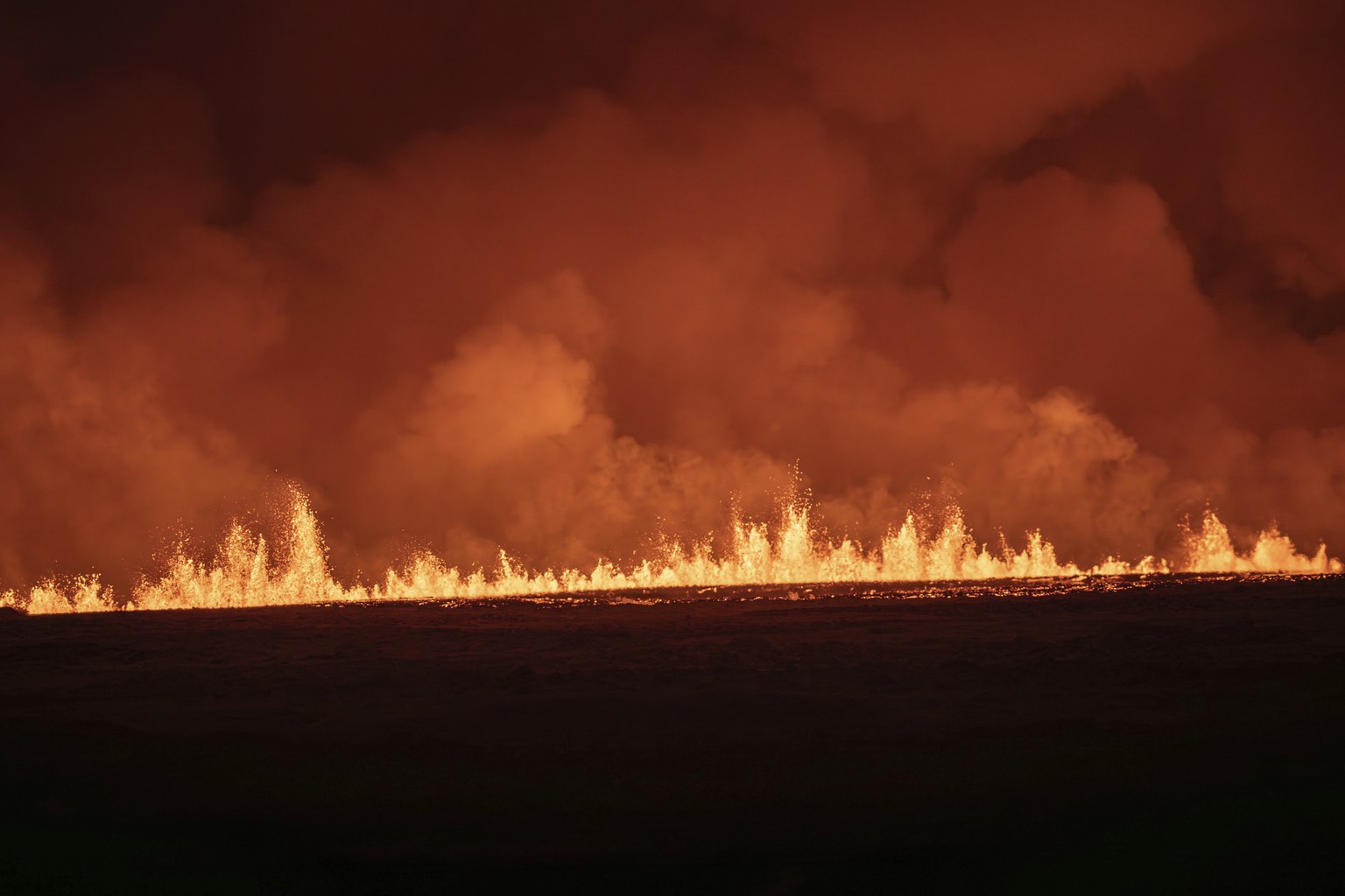 Lava fountains are seen as volcanic eruption started, turning the sky orange, in Grindavik on Iceland&#039;s Reykjanes Peninsula, Monday, Dec. 18, 2023. (AP Photo/Marco Di Marco)