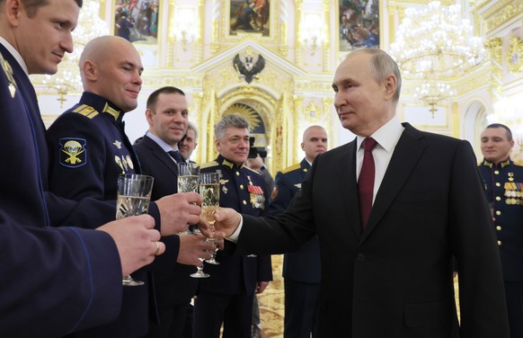 epa10355043 Russian President Vladimir Putin (front R) toasts with servicemen awarded with Gold Star medals of Heroes of Russia during a ceremony to award Golden Star medals to Heroes of Russia in the ...
