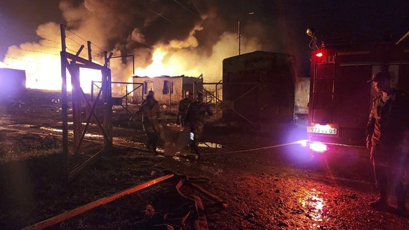 epa10884864 A handout photo made available by Artsakh / Nagorno-Karabakh Human Rights Ombudsman shows firefighters on the site of the fire after an explosion of the petrol warehouse near the Stepanake ...