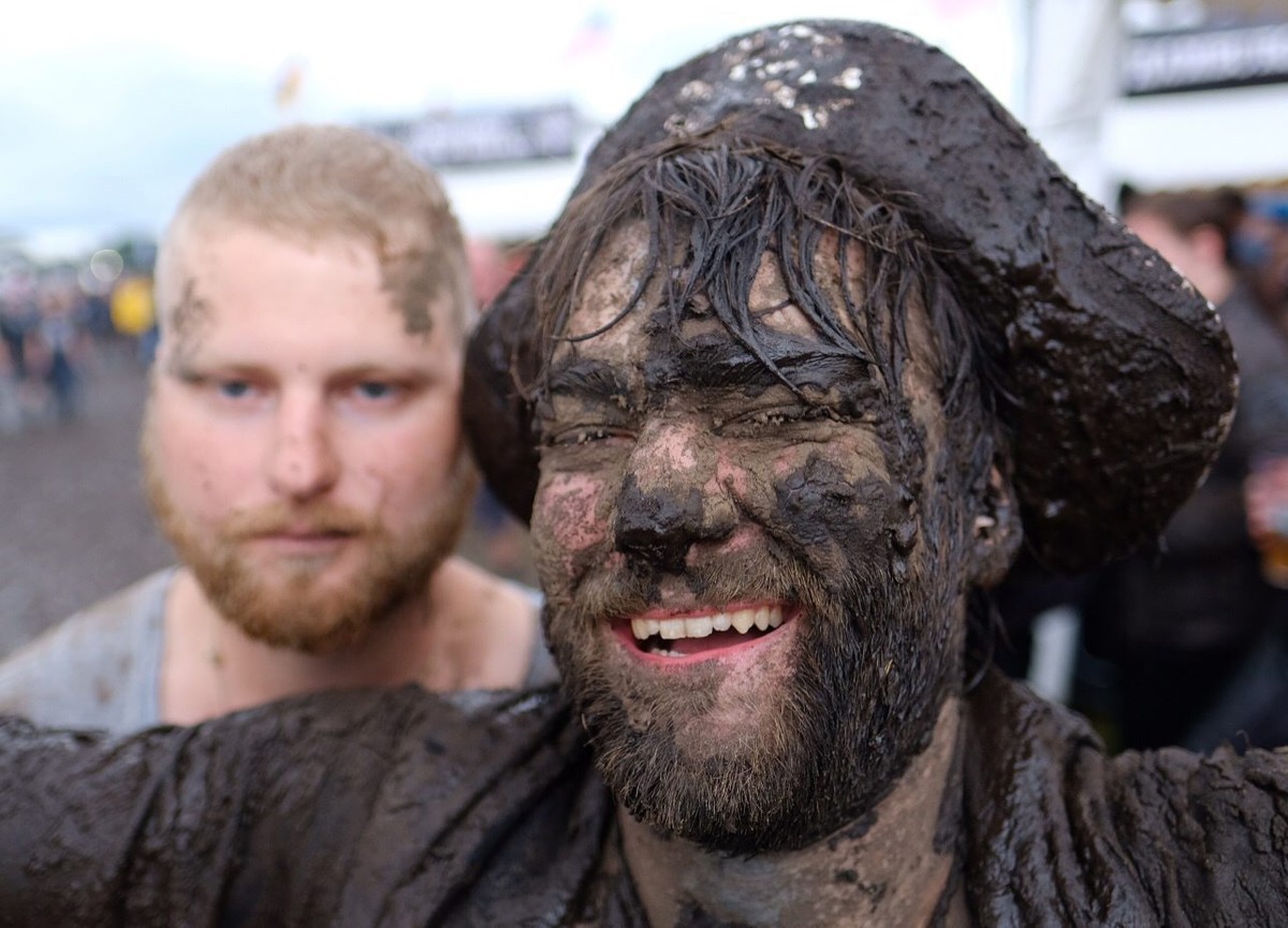 epa05453833 A heavy metal fan is covered in mud as he poses during the Wacken Open Air, in Wacken, Germany, 03 August 2016. The W:O:A festival is the world's largest heavy metal music event and r ...