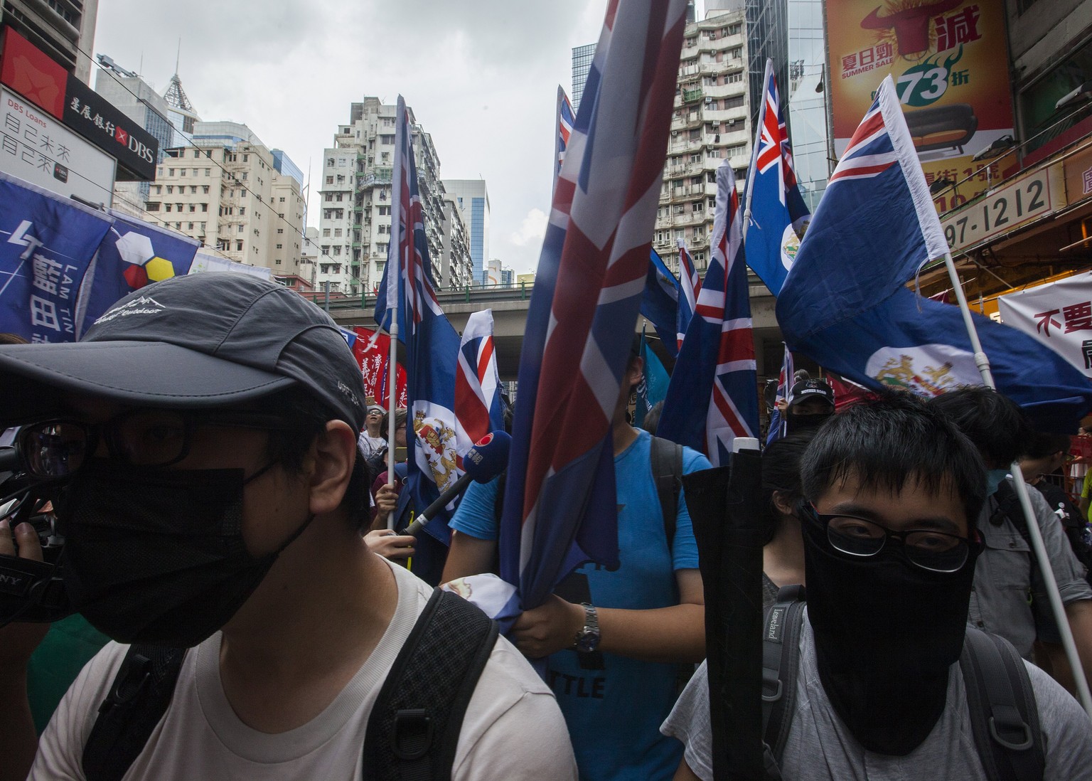 epa06059686 Pro-independence demonstrators wearing masks marching through the streets of Hong Kong during a protest on the 20th anniversary of the handover of sovereignty from Britain to China on 01 J ...