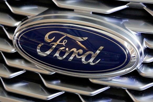 FILE- This Feb. 15, 2018, file photo shows a Ford logo on the grill of a car on display at the Pittsburgh Auto Show. Ford is recalling nearly 1.3 million Focus compact cars in the U.S. because a fuel  ...