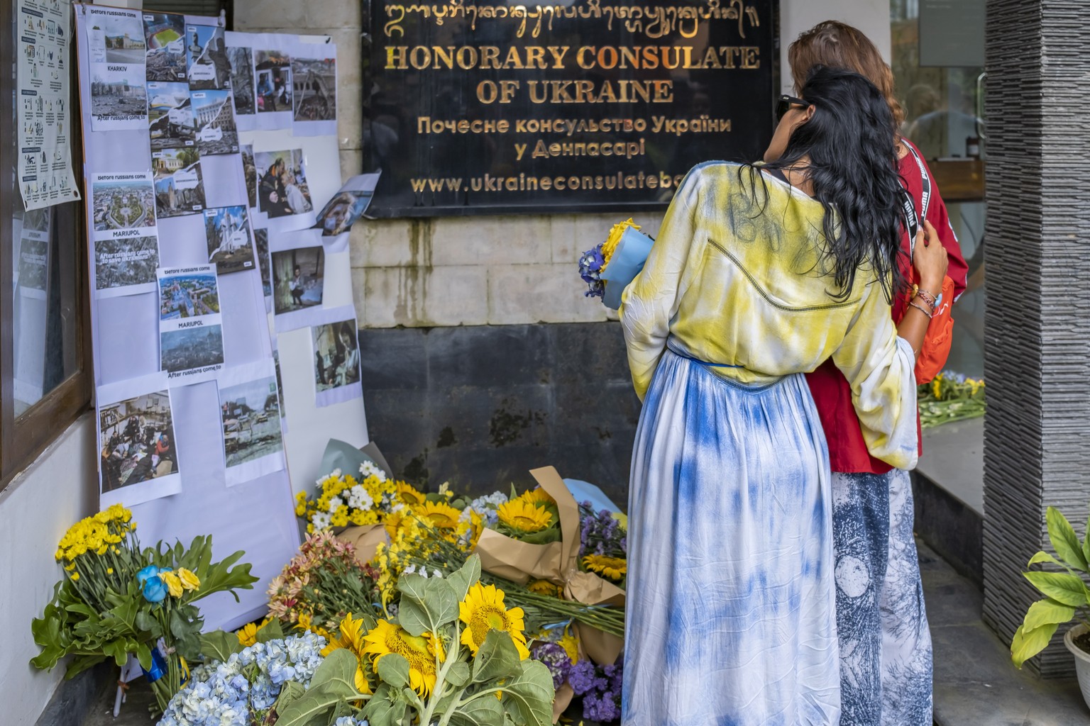 epa10487423 Ukrainian women lay flowers during a vigil in Denpasar, Bali, 24 February 2023. Ukrainians in Bali marked the first anniversary of the Russian invasion of Ukraine with a vigil outside the  ...