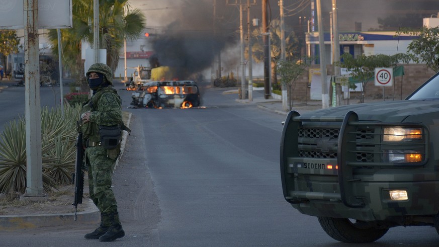 epa10390664 A cargo vehicle in flames after clashes between federal forces and armed groups in the city of Culiacan, state of Sinaloa, Mexico, 05 January 2023. Authorities in Culiacan, in the northern ...