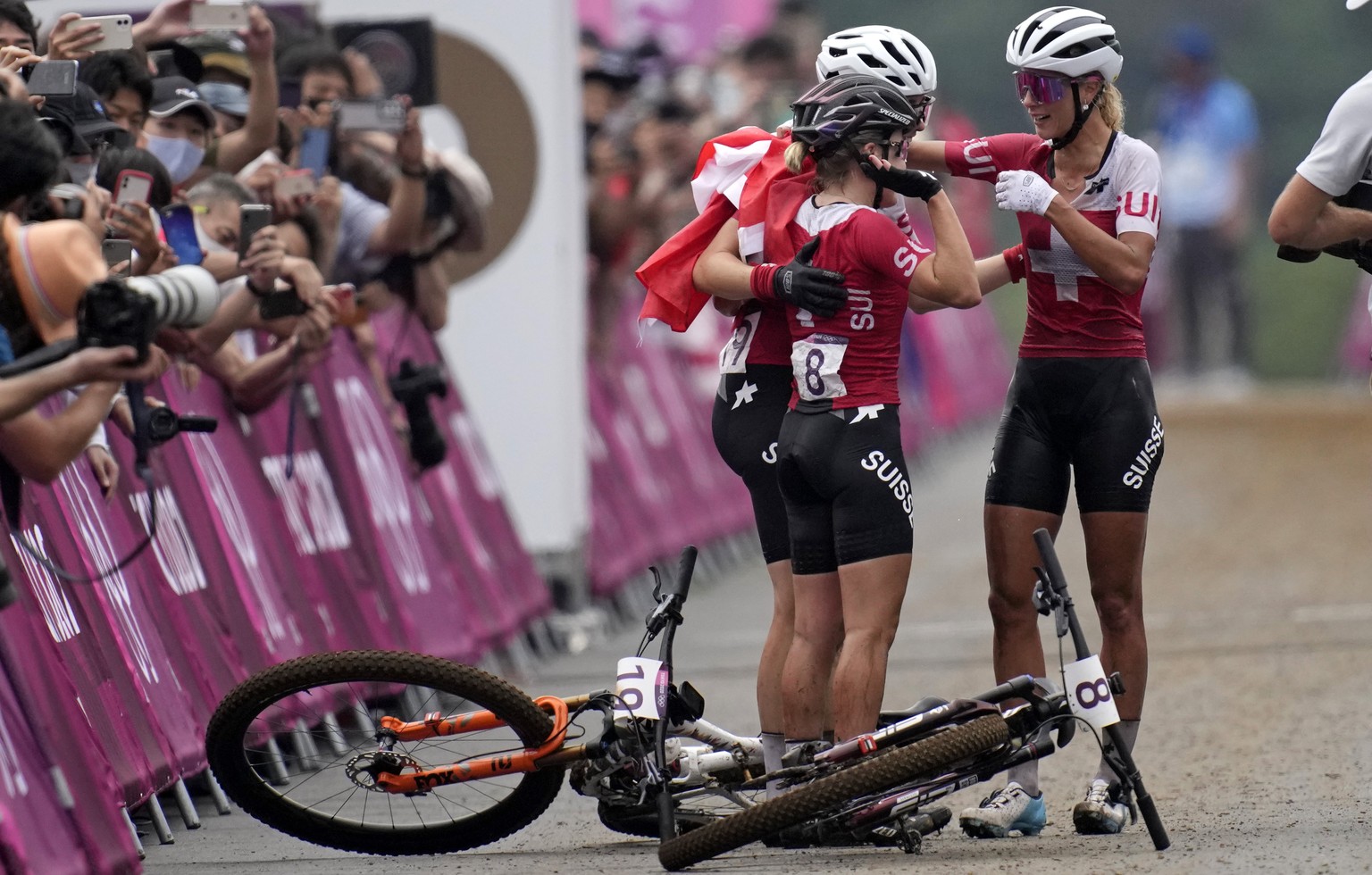 Jolanda Neff of Switzerland, right, embraces teammates Sina Frei (8) who won silver, and Linda Indergand, who won bronze, for a sweep of the podium for Switzerland, at the finish line the women&#039;s ...