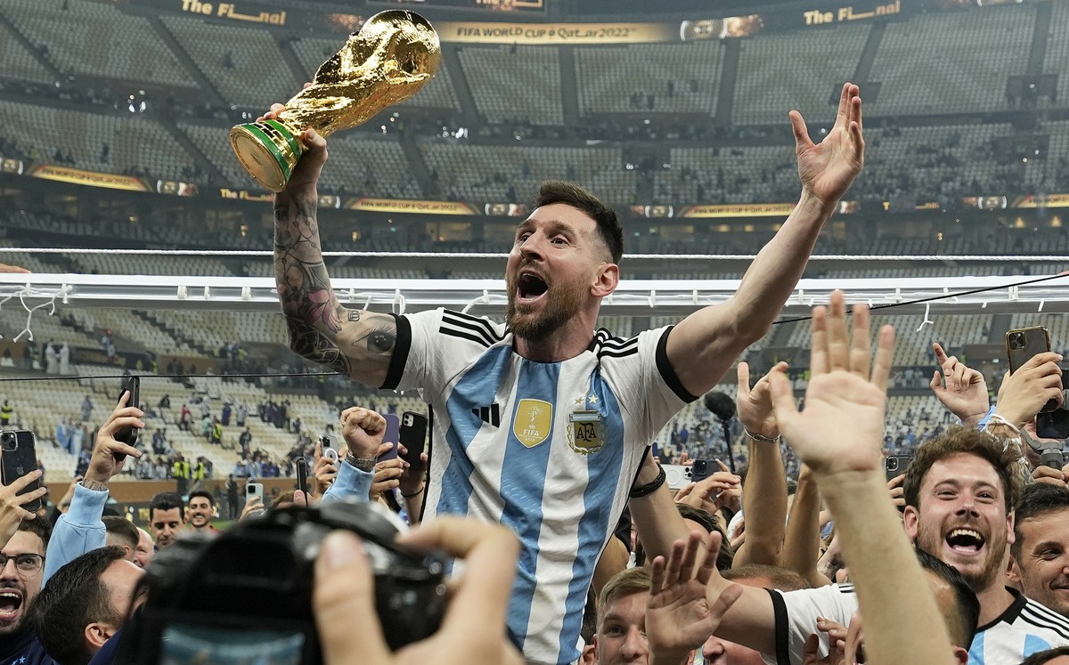 FILE - Argentina's Lionel Messi celebrates with the trophy in front of the fans after winning the World Cup final soccer match between Argentina and France at the Lusail Stadium in Lusail, Qatar, ...
