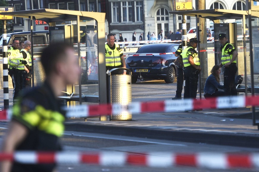 epa06021784 Police officers investigate at the Amsterdam Centraal station in Amsterdam, Netherlands, 10 June 2017. A car plowed into pedestrians and injured at least five people outside the station. T ...