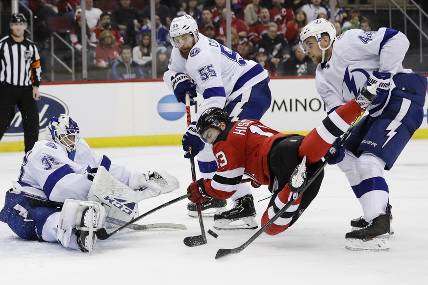 Tampa Bay Lightning&#039;s Braydon Coburn (55) breaks up a shot on goal by New Jersey Devils&#039; Nico Hischier (13) as goaltender Curtis McElhinney (35) and Jan Rutta (44) watch during the second pe ...