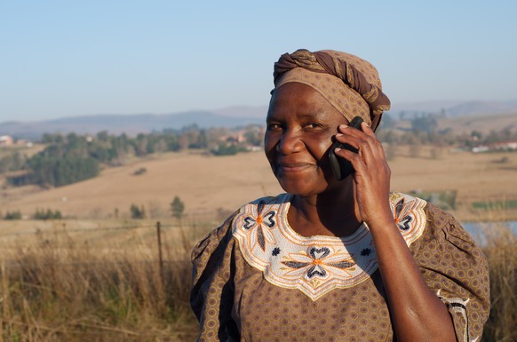 Afrikanerin mit Handy am Ohr.