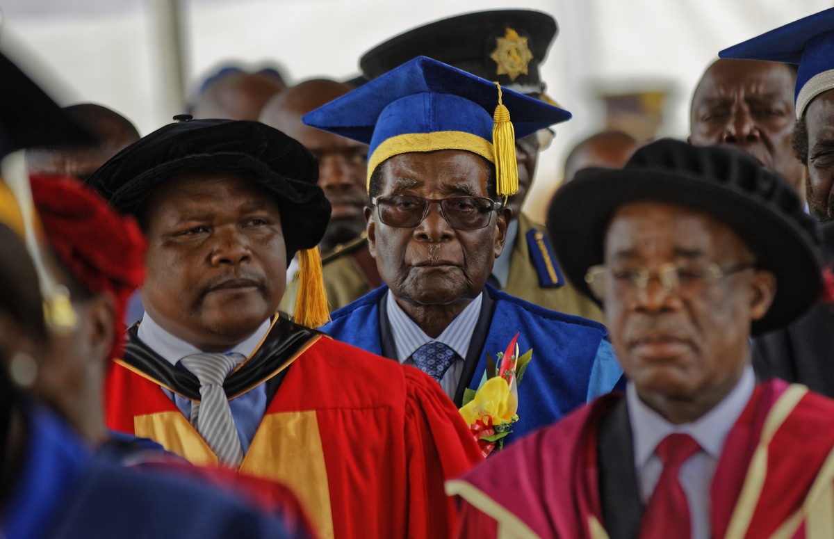 Zimbabwe's President Robert Mugabe, center, arrives to preside over a student graduation ceremony at Zimbabwe Open University on the outskirts of Harare, Zimbabwe Friday, Nov. 17, 2017. Mugabe is ...