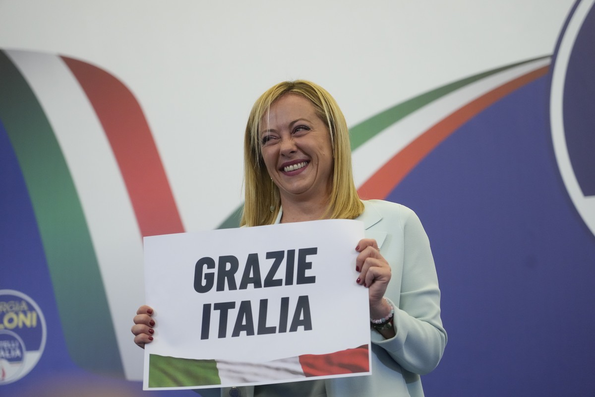 Far-Right party Brothers of Italy's leader Giorgia Meloni shows a placard reading in Italian "Thank you Italy" at her party's electoral headquarters in Rome, early Monday, Sept. 26 ...