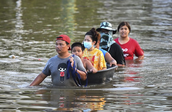 Thai people wade through floodwaters in Chaiyaphum province, northeast of Bangkok, Thailand, Tuesday, Sept. 28, 2021. Thai disaster officials say flooding caused by seasonal monsoon rains have affecte ...