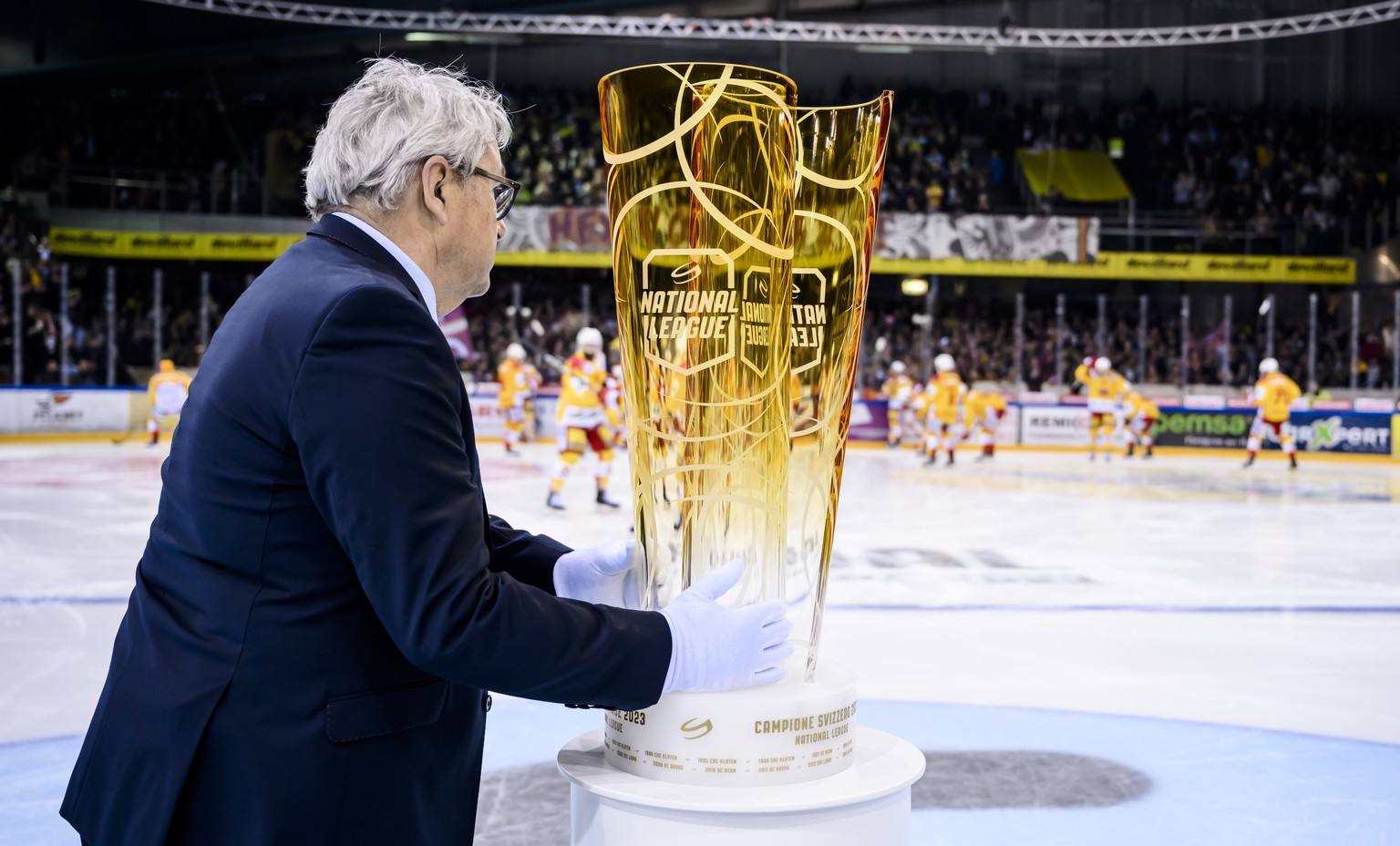 Willi Voegtlin, responsable des calendriers pour la Ligue, apporte la Coupe lors du premier match de la finale des play-off du Championnat de Suisse de hockey sur glace de National league entre le Gen ...