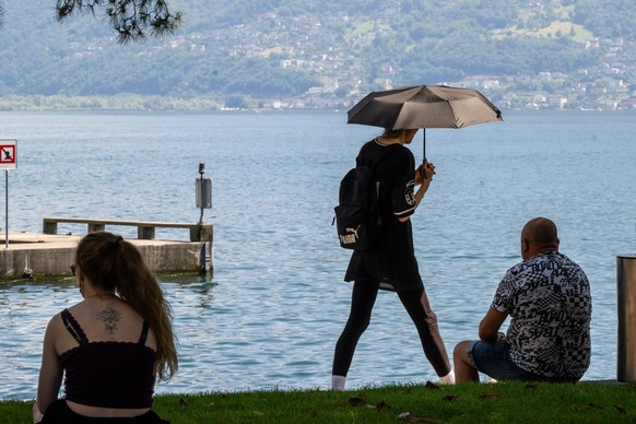 Tourists seeking shade and a cool spot by the lake in Locarno, in Ticino, a level 3 heatwave warning is in place due to high temperatures and sweltering heat; today the temperature reached 35°C Sunday ...