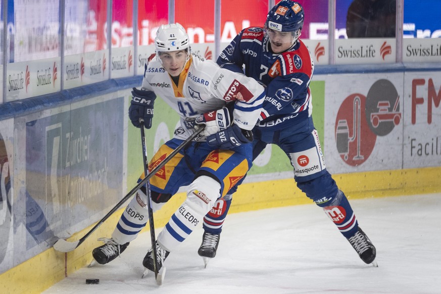 Leon Muggli (EVZ) (links) kaempft um den Puck mit Joel Henry (ZSC) (rechts) im Spiel der Eishockey National League zwischen ZSC Lions, ZSC, und EV Zug, EVZ, vom Samstag, 11. Januar 2025 in Swiss Life  ...