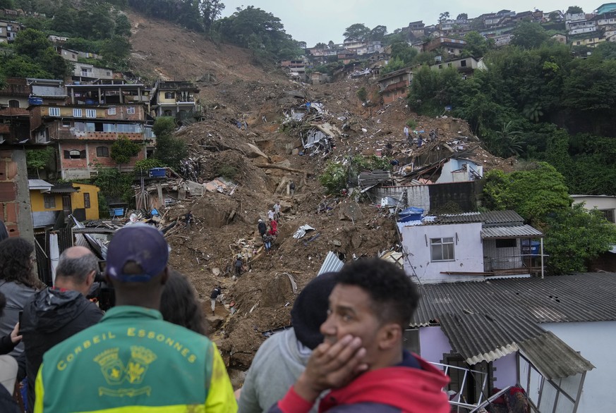 Rescue workers and residents look for victims in an area affected by landslides in Petropolis, Brazil, Wednesday, Feb. 16, 2022. Heavy rains set off mudslides and floods in a mountainous region of Rio ...
