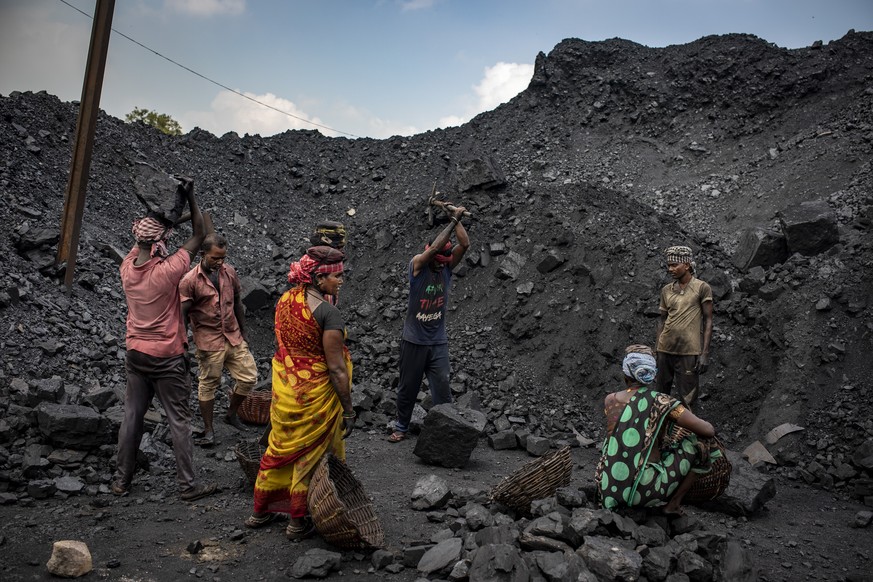 FILE- Laborers load coal onto trucks for transportation near Dhanbad, an eastern Indian city in Jharkhand state, Friday, Sept. 24, 2021. India has yet to submit its targets for cutting greenhouse emis ...