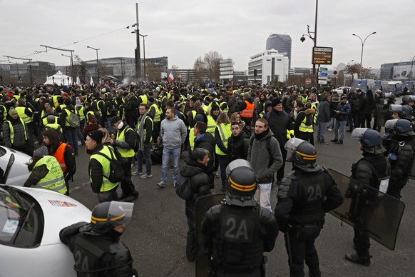 epa07253165 Protesters are blocked by the French riot police in front of the French notional television building during a &#039;Yellow Vests&#039; protest in Paris, France, 29 December 2018. The so-ca ...