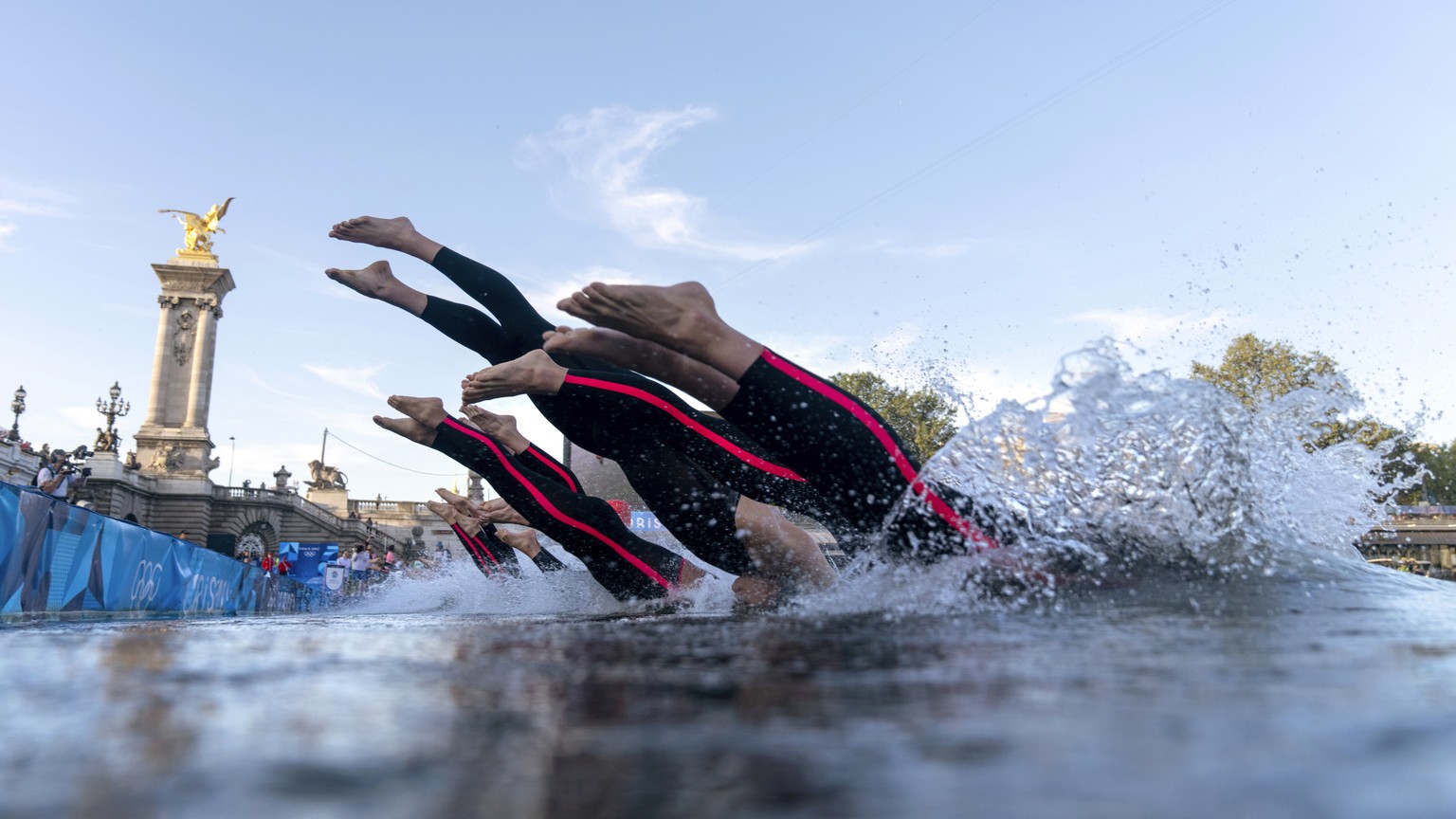 Competitors dive into the Seine river at the start of the men&#039;s 10km, marathon swimming, at the 2024 Summer Olympics, Friday, Aug. 9, 2024, in Paris, France. (AP Photo/David Goldman, Pool)