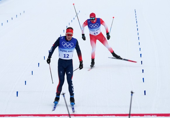 epa09770910 Andrew Musgrave (front) in the finish ahead of Dario Cologna of Switzerland in the Men&#039;s 50km Mass Start race at the Zhangjiakou National Cross-Country Skiing Centre at the Beijing 20 ...