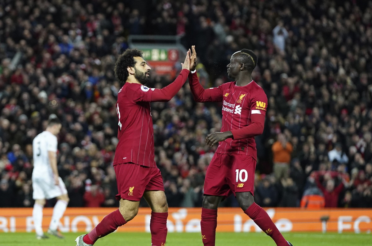 Liverpool's Mohamed Salah, front left, celebrates with Liverpool's Sadio Mane after scoring his side's opening goal during the English Premier League soccer match between Liverpool and  ...