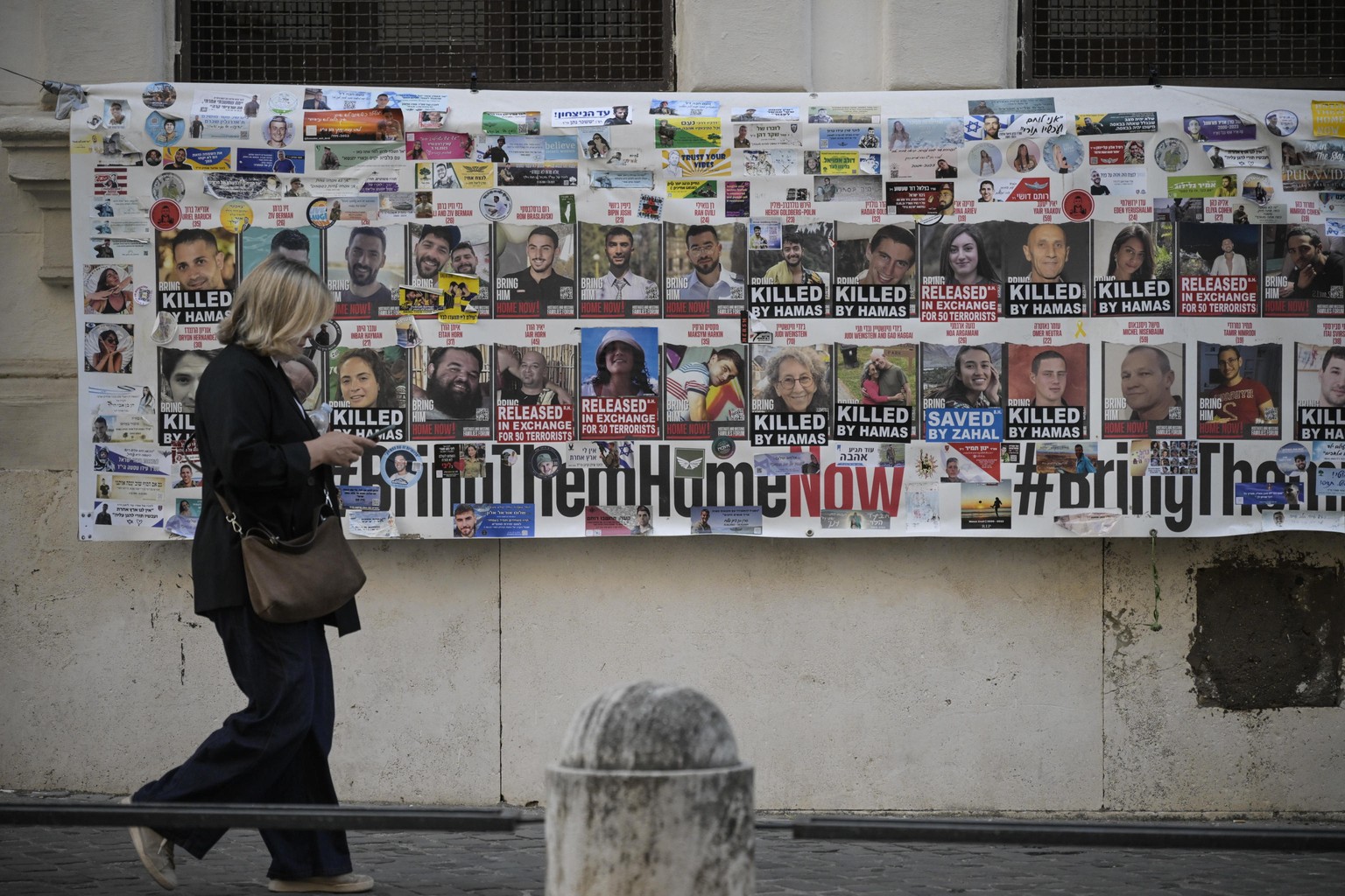 epa12442680 A banner with the faces of kidnapped and killed people in the October 7 2023 attacks on a wall in the Jewish Ghetto in Rome, Italy, 9 October 2025. EPA/Riccardo Antimiani