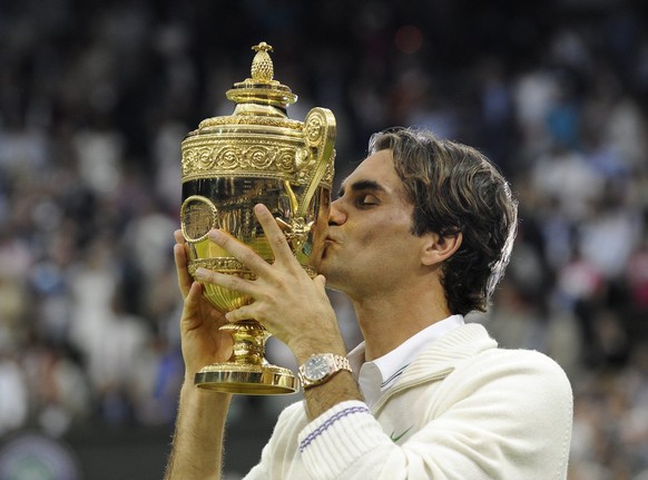 epa03300941 Roger Federer of Switzerland kisses the Championship trophy after defeating Andy Murray of Britain in the men&#039;s singles final of the Wimbledon Championships at the All England Lawn Te ...