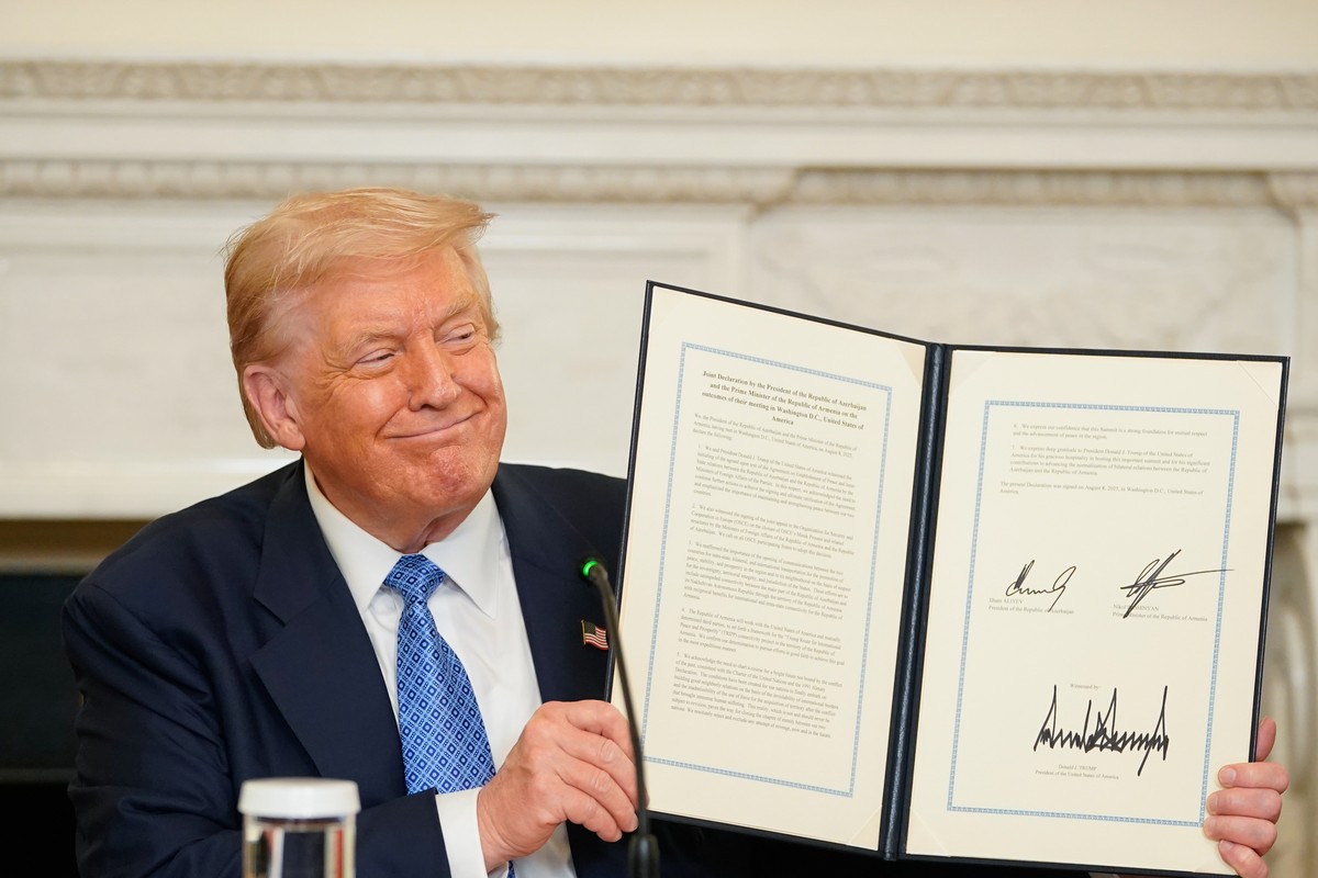 epa12290515 US President Donald Trump displays a signed agreement during a signing ceremony in the State Dining Room of the White House in Washington, DC, USA, 08 August 2025. US President Trump said  ...