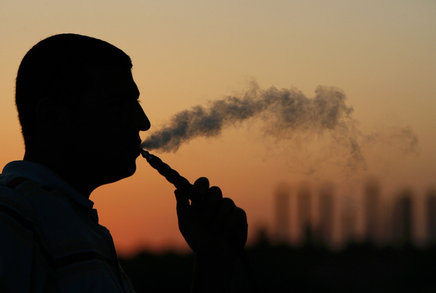 A Lebanese man smokes a tobacco water-pipe as the sun sets in the southern port city of Tyre, Lebanon, Wednesday, September 13, 2006. (KEYSTONE/AP Photo/Alvaro Barrientos)