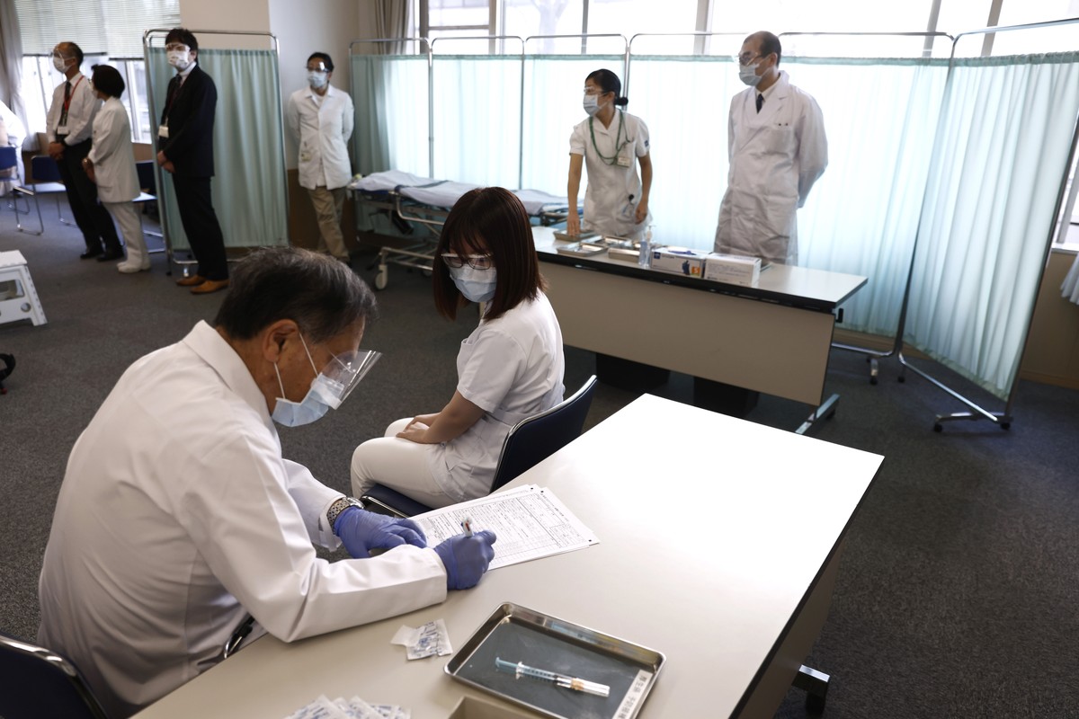 A medical worker checks the form of his colleague before giving her a dose of the COVID-19 vaccine at Tokyo Medical Center in Tokyo Wednesday, Feb. 17, 2021. Japan's first coronavirus shots were  ...