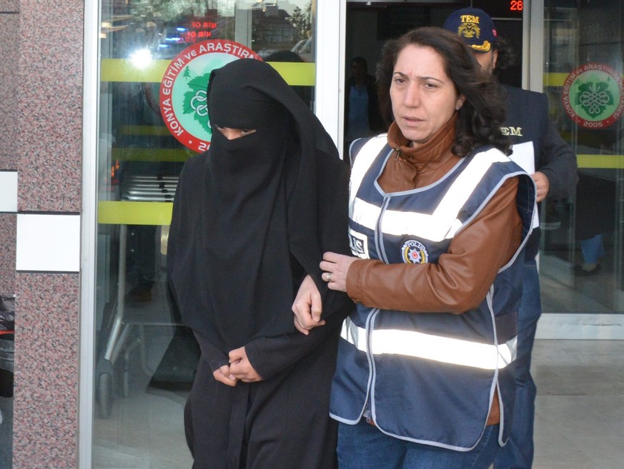 epa04998117 A female Turkish police officer (R) escorts an unidentified &#039;Islamic State&#039; (IS) suspect in Konya, Turkey 27 October 2015. Media reports state that Turkish police arrested 30 Isl ...
