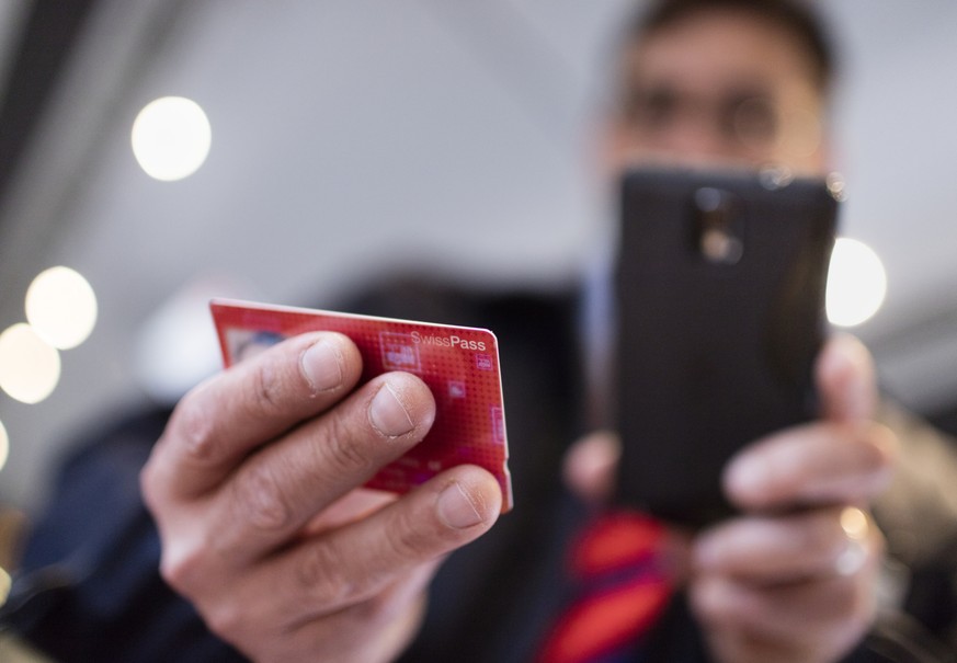 ZUR EINFUEHRUNG DES SWISSPASSES VOR DREI MONATEN STELLEN WIR IHNEN HEUTE, MITTWOCH, 4. NOVEMBER 2015, FOLGENDES NEUES BILDMATERIAL ZUR VERFUEGUNG --- A conductor verifies a train passenger&#039;s Swis ...