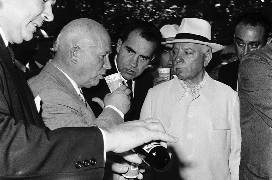 Chruschtschow nippt an einem kapitalistischen Softdrink. Kendall schenkt ein, Nixon (3.v.l.) guckt zu.