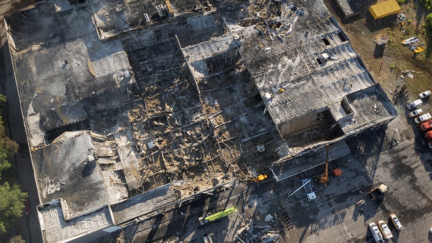 Ukrainian State Emergency Service firefighters work to take away debris at a shopping center burned after a rocket attack in Kremenchuk, Ukraine, Tuesday, June 28, 2022. (AP Photo/Efrem Lukatsky)